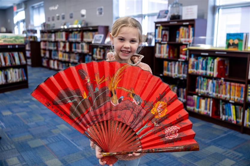 Students make red envelopes in the library